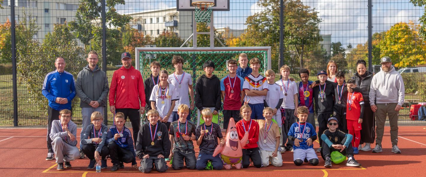 Kinder auf Sportplatz als Gruppenbild bei gutem Wetter