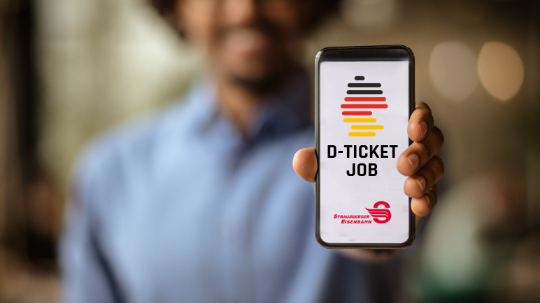 Mann hält Handy in Kamera auf dem Deutschlandticket Job von STE sichtbar ist